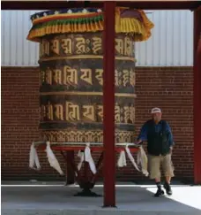  ?? ANDREW FRANCIS WALLACE/TORONTO STAR ?? Outside the Tibetan Canadian Cultural Centre, you’ll find two enormous prayer wheels. Here, a Tibetan man walks to turn a wheel clockwise.