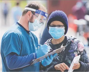  ?? GRAHAM HUGHES/THE CANADIAN PRESS ?? A health-care worker takes a woman’s details at a mobile COVID-19 testing clinic in Montreal on Sunday.