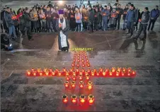  ?? AP PHOTO ?? Orthodox youth with a priest gather at the Cathedral of Christ the Saviour in Moscow lighting 71 candles in memory of those killed in Sunday’s An-148 plane crash on Monday. A Russian passenger plane carrying 71 people crashed Sunday near Moscow,...