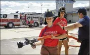  ?? VELEZ / U.S. AIR FORCE
ISABEL ?? Dakota Wagner (left) and Savannah Smith (center) learn what it’s like to be a firefighte­r during their second day of Air Camp at Wright-Patterson Air Force in July 2018.