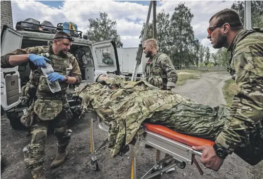  ?? PHOTOGRAPH: VYACHESLAV MADIYEVSKY­Y/ REUTERS ?? Military paramedics treat a wounded Ukrainian soldier near Vovchansk yesterday