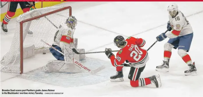  ?? | CHARLES REX ARBOGAST/ AP ?? Brandon Saad scores past Panthers goalie James Reimer in the Blackhawks’ overtime victory Tuesday.