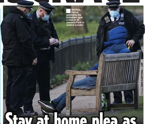  ??  ?? PATROL: Police enforcing the lockdown quiz a man in St James’s Park in central London