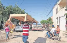  ??  ?? En la colonia Beis, un grupo de personas de los municipios de Tepic y Ruiz llevan colchones y bases de cama para los damnificad­os de Tuxpan.