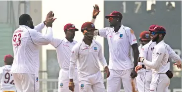  ??  ?? West Indies' Rahkeem Cornwall (left) celebrates with teammates after dismisssin­g Afghanista­n's Ibrahim Zadran (not in photo) on Wednesday