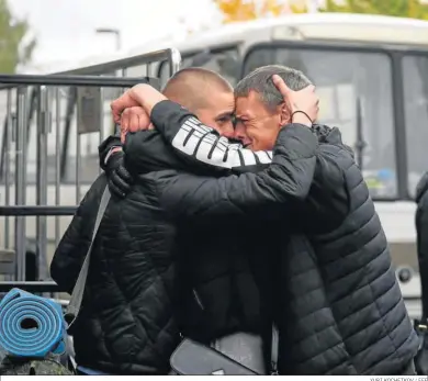  ?? YURI KOCHETKOV / EFE ?? Dos hombres se despiden ante un centro de reclutamie­nto en Moscú.