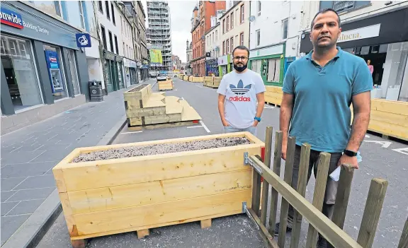  ?? Picture: Dougie Nicolson. ?? Kadir Yilmaz, left, of Top Class Turkish Barbers, and Imran Javid of Mobile Solutions beside some of the street furniture that has been placed along High Street, Perth.