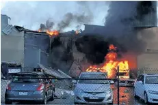  ?? JORDAN FOURACRE/GETTY IMAGES ?? The flaming wreckage of a small plane is seen after it crashed into a mall in Essendon, Australia, on Tuesday. The pilot and four American tourists were killed in the accident.