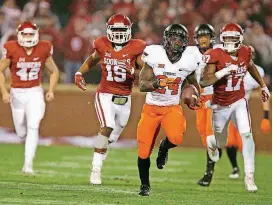  ?? [PHOTO BY SARAH PHIPPS, THE OKLAHOMAN] ?? Tyreek Hill breaks into the clear on his way to a 92-yard punt return that sent the 2014 Bedlam game into overtime.