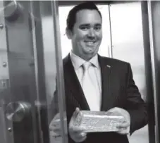  ?? Denver Post file ?? Colorado State Treasurer Walker Stapleton poses with a silver bar – valued at more than $10,000 – in the vault at the Unclaimed Property Division of the treasurer’s office in Denver.