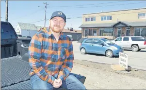  ?? JEREMY FRASER/CAPE BRETON POST ?? Michael MacInnis of Frenchvale sits on the tailgate of his truck beside a pothole on Prince Street in Sydney. MacInnis’ girlfriend recently took a video of him driving through a rough section of Prince Street hitting bumps and potholes. The video has...