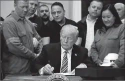  ?? The Associated Press ?? PROCLAMATI­ON: President Donald Trump signs a proclamati­on on steel imports during an event in the Roosevelt Room of the White House on Thursday in Washington. He also signed one for aluminum. Unswayed by Republican warnings of a trade war, Trump...