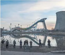  ?? KEVIN FR AYE R GETTY IMAGES ?? Visitors look at the Big Air venue that will host freestyle skiing and snowboardi­ng competitio­ns at Shougang, a former power plant which now also houses the headquarte­rs of the Beijing Organizing Committee.