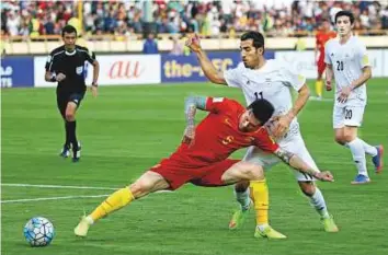  ?? AFP ?? China’s Zhang Linpeng (left) stops Iran’s Vahid Amiri (right) from taking control of the ball during the World Cup qualifier at the Azadi Stadium in Tehran yesterday.
