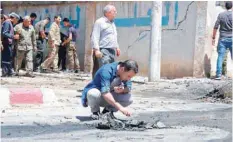  ?? — AFP ?? A member of the Kurdish security examines debris at the site of a explosive-rigged vehicle that detonated in the town of Al Qahtaniyah on Wednesday.