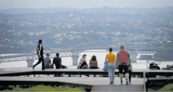  ?? Photo / Alex Burton ?? There were grey skies — but no rain — as people enjoyed the view over Auckland Harbour from Mt Eden yesterday.