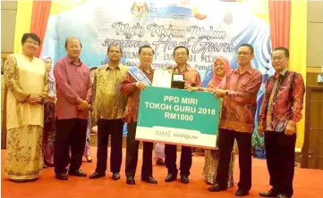  ??  ?? Fong (fourth left) receives ‘Tokoh Guru’ award from Kamarulzam­an (second right), witnessed by Dr Teo (fourth right) and other guests.