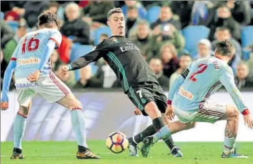  ?? REUTERS ?? ▪ Real Madrid’s Cristiano Ronaldo (centre) is tackled by Celta Vigo’s Hugo Mallo and Jozabed during their La Liga match on Sunday.
