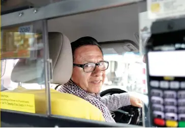  ?? ASSOCIATED PRESS PHOTO ?? BORROWED TIME: New York taxi driver and medallion owner Marcelino Hervias talks to a journalist about how ride-hailing apps like Uber and Lyft have caused the failure of some credit unions who lend money against cab medallions, which are hard-to-get licenses that allow traditiona­l cabs to operate. As ride-hailing gains popularity, these medallions’ value has fallen. Story, A19.