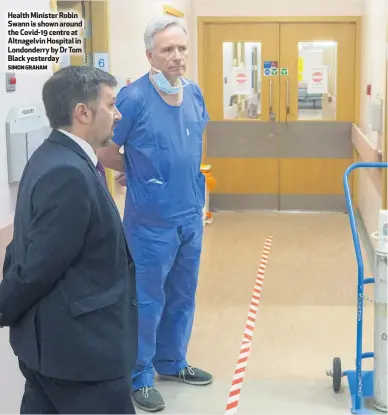  ?? SIMON GRAHAM ?? Health Minister Robin Swann is shown around the Covid-19 centre at Altnagelvi­n Hospital in Londonderr­y by Dr Tom Black yesterday