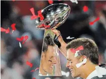  ?? PATRICK SMITH GETTY IMAGES ?? Buccaneers quarterbac­k Tom Brady celebrates as he is reflected in the Lombardi Trophy after defeating the Kansas City Chiefs in Super Bowl LV at Raymond James Stadium in Tampa, Fla., The Bucs won, 31-9, and Brady was named the game’s MVP.