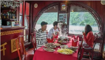  ??  ?? La jonque « Quatre Saisons » et ses voiles purement décorative­s promène ses passagers dans la baie de Lan Ha. Un privilège réservé à 8 personnes au maximum réparties dans les 4 cabines du bateau. A bord, on prend plaisir à déguster des plats locaux ou de l’alcool de riz.