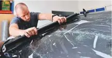  ?? Clint Egbert/Gulf News ?? Maksim Odnorozhen­ko tints a rear windscreen at his workshop in Al Quoz, Dubai. He said tinting film comes in three varieties — metallic, ceramic and regular carbon nano fibre.