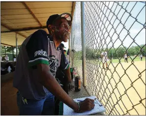  ?? Arkansas Democrat-Gazette/THOMAS METTHE ?? Saul Simpson, assistant coach for the Florida-based Resmondo softball team, keeps statistics and cheers on his team Saturday during the Busch Softball Classic at the Sherwood Sports Complex.