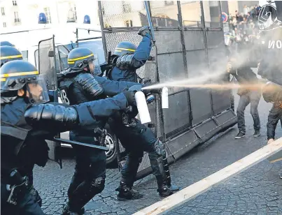  ?? Picture: AP. ?? Police spray tear gas on demonstrat­ors during the political protests in Paris yesterday.