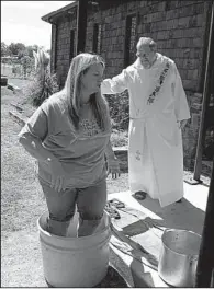  ?? NWA Media/DAVE HUGHES ?? Under the watchful eye of the Rev. Don Gregory Pilcher on Saturday, Kristi Pfeiffer of Paris carries on the tradition of being the first person to stomp the grapes at Cowie Wine Cellars’ wine festival and grape stomp.