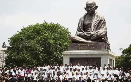  ?? — AP ?? Unhappy with outcome: Supporters of the Indian National Congress and Janata Dal alliance protesting in front of Mahatma Gandhi’s statue after disagreein­g with the swearing-in of BJP leader Yeddyurapp­a as Chief Minister of Karnataka state in Bangalore.