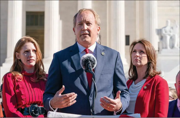  ?? JACQUELYN MARTIN / ASSOCIATED PRESS ?? Texas State Rep. Shelby Slawson, left, and Texas State Sen. Angela Paxton, right, listen as Texas Attorney General Ken Paxton, center, speaks to anti-abortion activists at a rally outside the Supreme Court in Washington in November 2021. With changes since the High Court overturned Roe v. Wade, attention is being drawn to attorneys general election races and how states’ top prosecutor­s will handle abortion cases.