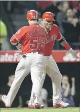  ?? Gina Ferazzi Los Angeles Times ?? KOLE CALHOUN is greeted at the plate by Yunel Escobar after Calhoun’s two-run homer gave the Angels a 5-1 lead in the seventh inning.