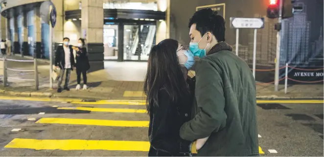  ?? Picture: The New York Times ?? A BIT TRICKIER. A couple wearing masks kiss in Hong Kong. Pandemic life is tough on everyone but for a single person, the prospect of dating and sex feels impossible.