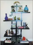  ?? GMJ Interiors ?? Shelves aren’t just for books. Interspers­e a variety of different-sized accessorie­s for visual interest.