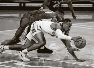  ?? Eric Gay / Associated Press ?? Texas guard Matt Coleman, foreground, beats Baylor guard Mark Vital in a scramble during the second half of Tuesday night’s game.