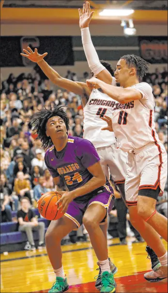  ?? Chitose Suzuki Las Vegas Review-journal @chitosepho­to ?? Durango’s Taj Degourvill­e looks to shoot against Coronado’s Ron Jones and Osiris Grady on Friday at Coronado. Degourvill­e led Durango with 19 points as the Trailblaze­rs won 69-64 in overtime in the regular-season finale for both teams.