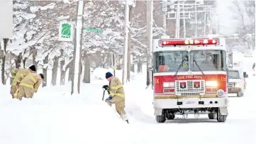  ??  ?? Erie firefighte­rs remove snow from around fire hydrants on West 8th street after two days of record-breaking snowfall in Erie, Pennsylvan­ia, US. — Reuters photo