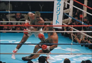  ?? TSUGUFUMI MATSUMOTO — THE ASSOCIATED PRESS ?? James Douglas, left, follows with a left, dropping Mike Tyson to the canvas in the 10th round Feb. 11, 1990, at the Tokyo Dome in Tokyo.