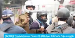  ??  ?? NEW DELHI: This photo taken on February 15, 2019 shows Delhi Traffic Police constable Sandeep Shahi (2L) holds up a mirror as part of a safety awareness campaign. — AFP