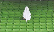  ?? (File Photo/AP/Kerstin Joensson) ?? A man dressed as a ghost stands on the empty tribune on March 12, 2020, prior the Europa League round of 16 first leg soccer match between Linzer ASK and Manchester United in Linz, Austria. The match was being played in an empty stadium because of the coronaviru­s outbreak.