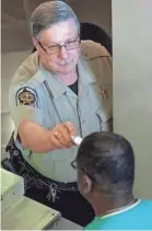  ?? MICKEY WELSH/USA TODAY NETWORK ?? A temperatur­e check is administer­ed at a checkpoint in a Montgomery County Courthouse building in Montgomery, Ala.