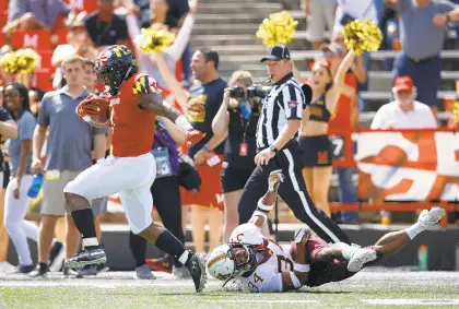  ?? PATRICK SEMANSKY/AP ?? Maryland wide receiver DJ Turner, left, runs past Minnesota defensive back Antonio Shenault for a touchdown in the first half Saturday.