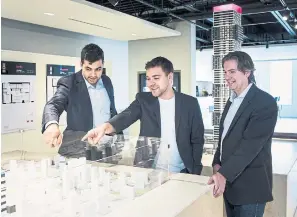  ?? NICK KOZAK FOR THE TORONTO STAR ?? Ramzi Cotran, left, checks out a scale model of his new neighbourh­ood with Joseph Feldman, director of developmen­t at Camrost Felcorp, and Henry Burstyn, right, architect at IBI Group.