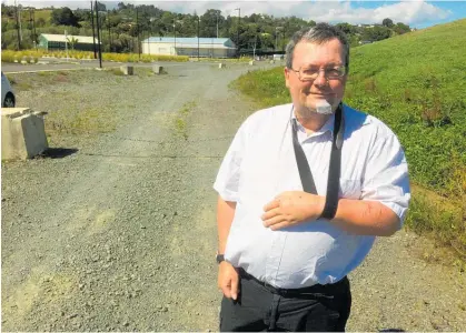  ?? Photo / Susan Botting ?? Injured cyclist Michael Jones in front of the “impossible to see grey on grey” Pohe Island rally road chain.