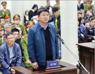  ?? AFP/ VIETNAM NEWS AGENCY ?? Dinh La Thang (centre), former politburo member and former chairman of Vietnam’s National Oil Company PVN (PetroVietn­am), stands trial next to Trinh Xuan Thanh (sitting left), a former oil executive, at the courtroom of Hanoi People’s Court yesterday.