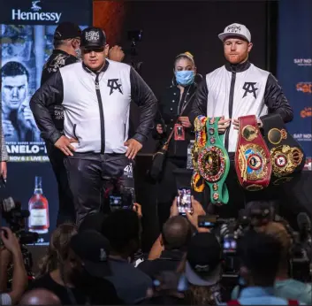  ?? Las Vegas Review-journal @Left_eye_images ?? L.E. Baskow
Super-middleweig­ht champion Canelo Alvarez poses with his title belts alongside trainer Eddy Reynoso during a news conference Wednesday at MGM Grand Garden.