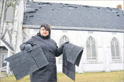  ?? SHARON MONTGOMERY-DUPE/CAPE BRETON POST ?? Melanie Sampson, chair of the Stone Church Restoratio­n Society, holds up some of the pieces of shingle found on the ground at the former St. Alphonsus church in Victoria Mines after the new roof was damaged during a wind storm on Thursday.