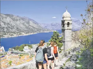  ?? STEVE MACNAULL PHOTO ?? Hikers approach the Our Lady of Remedy church along the city wall of Kotor, Montenegro.