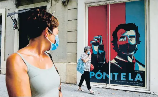  ?? QUIQUE GARCÍA / EFE ?? Un grafiti con la imagen de Fernando Simón preside la entrada de un comercio del barrio del Eixample de Barcelona